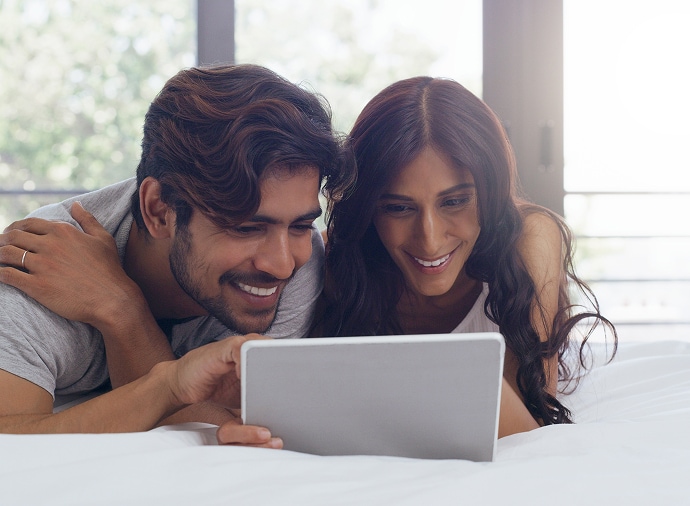 タブレットを見ながら笑う男性と女性