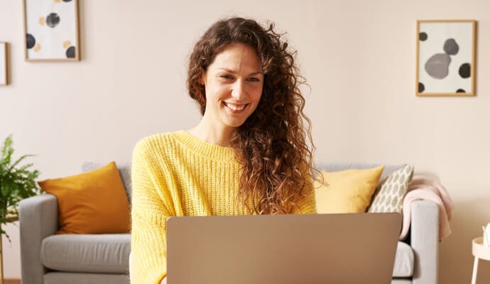 ノートパソコンでノートン・セーフサーチを起動して微笑む女性